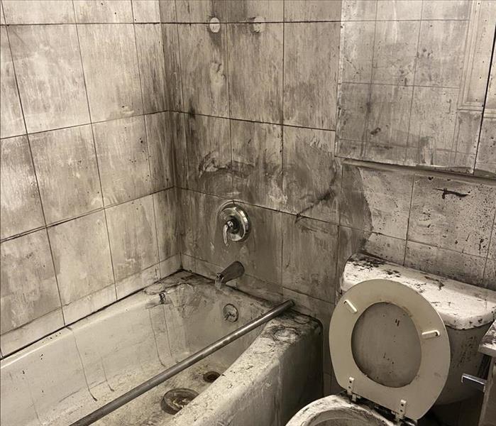 Bathroom is covered in soot after a fire damage.