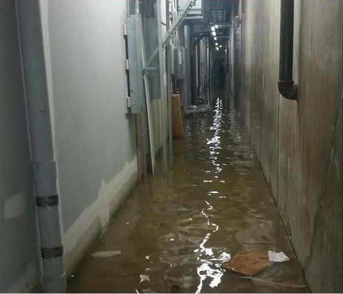 Water covers the hallway of an industrial manufacturing building.