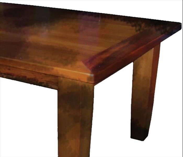 A wood table is damaged by fire and soot.