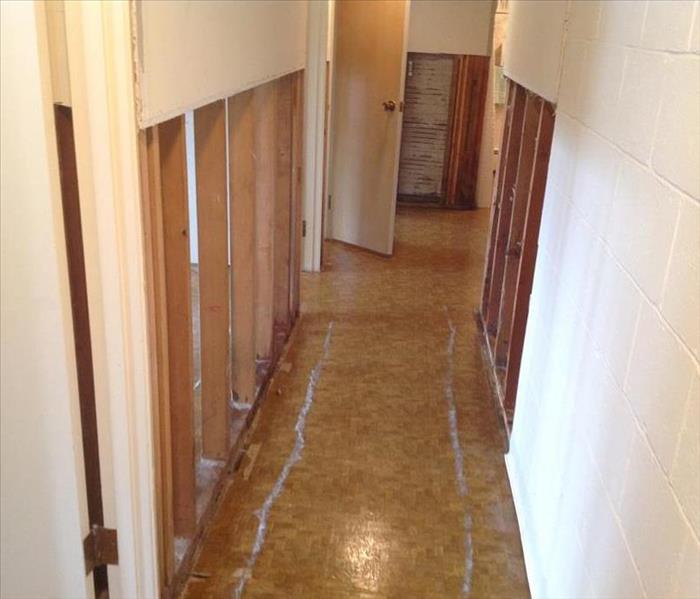 A hallway is drying and sheetrock is removed after a flood.