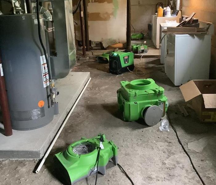 Drying equipment is positioned in a basement after flooding from a storm.