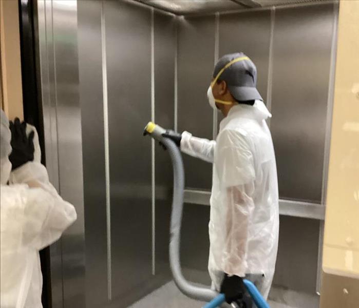 SERVPRO technician is sanitizing an elevator.