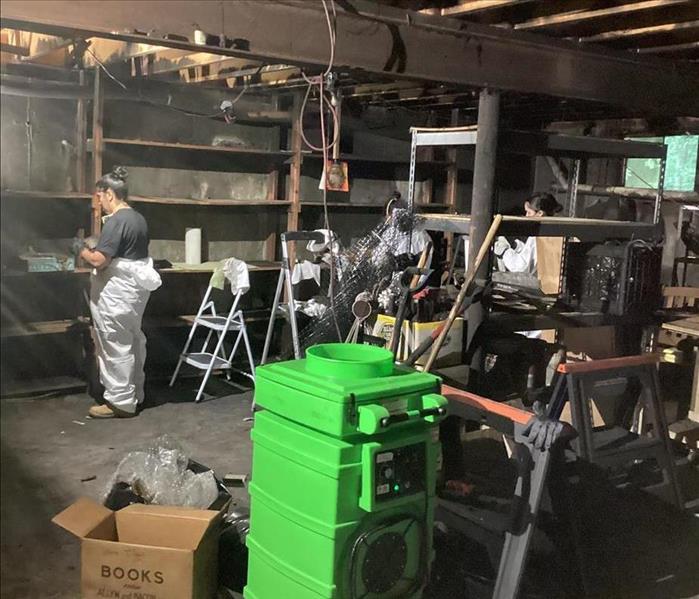 SERVPRO employees empty contents from a basement where a fire has occured.